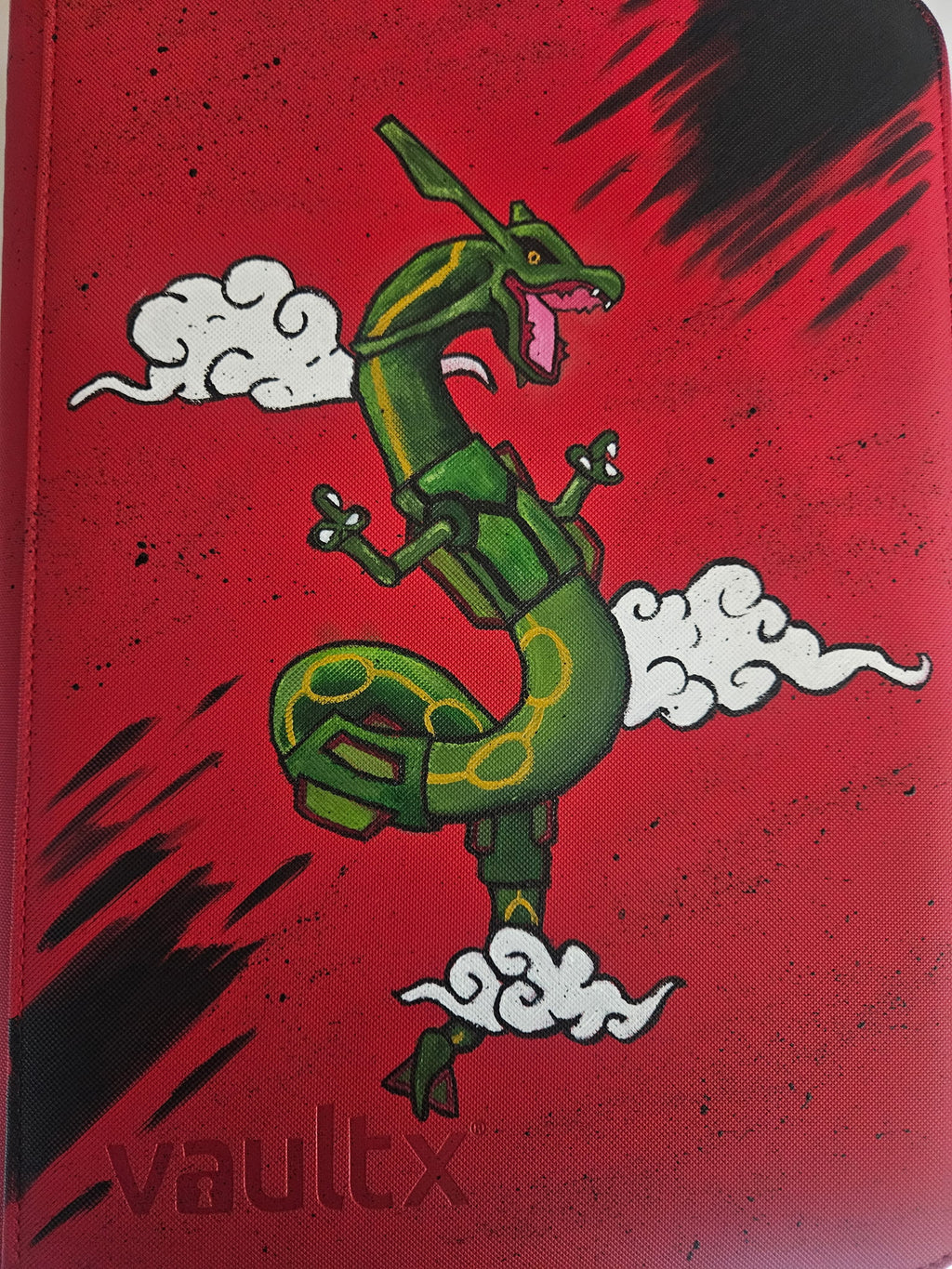 Front view of custom hand-painted Rayquaza Pokemon card binder — green Rayquaza with white cloud accents on red VaultX binder, one-of-a-kind freehand acrylic artwork by 5/14 Apparel
