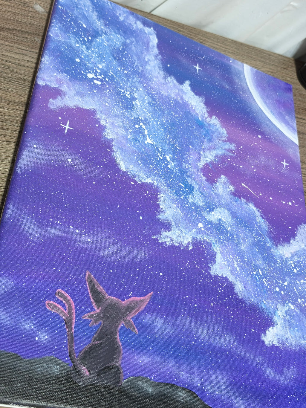 Close-up detail of hand-painted Espeon galaxy canvas — acrylic canvas texture visible with Espeon silhouette, swirling blue and purple star clouds, shooting stars, and crescent moon. 1 of 1 original by 5/14 Apparel.