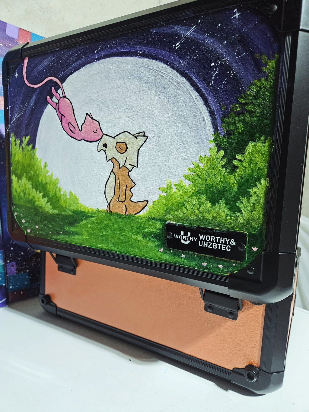 Side angle of custom hand-painted Cubone and Mew Pokemon slab case in orange — one-of-a-kind acrylic artwork sealed with UV and scratch-resistant coating by 5/14 Apparel
