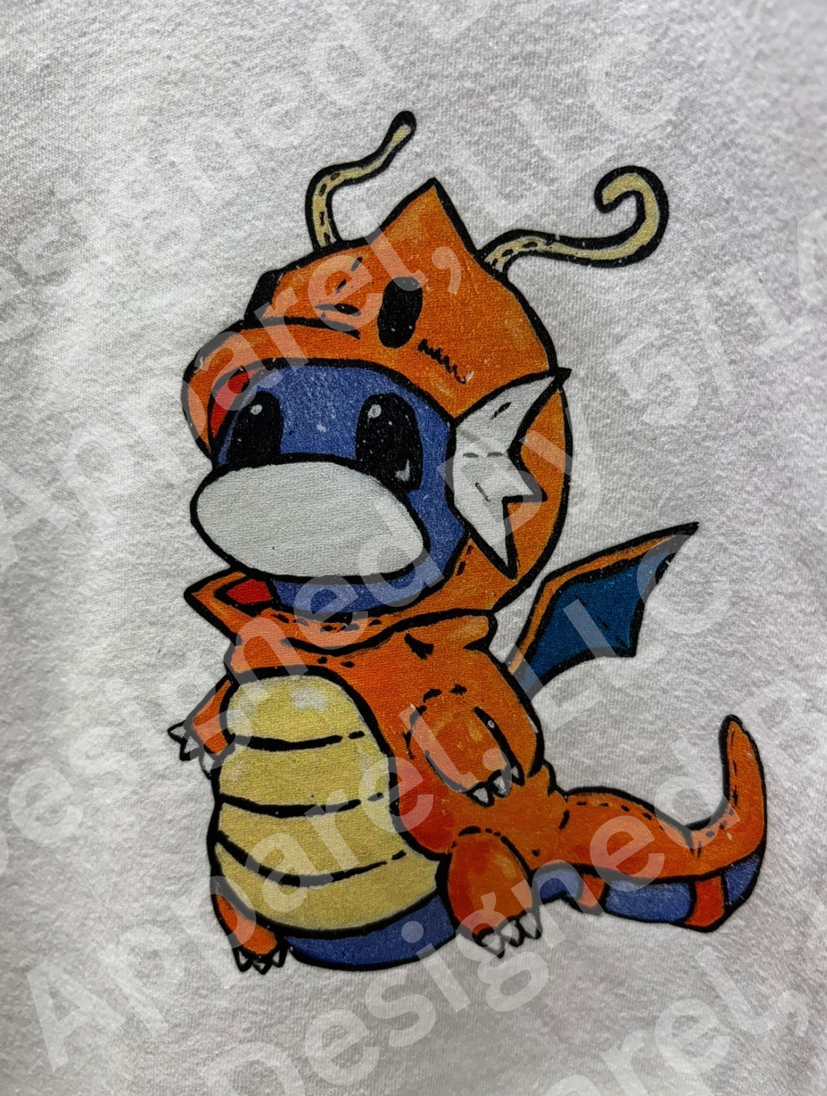 Close-up of Squirtle in Dragonite poncho graphic — hand-painted style Squirtle in orange Dragonite costume design by 5/14 Apparel