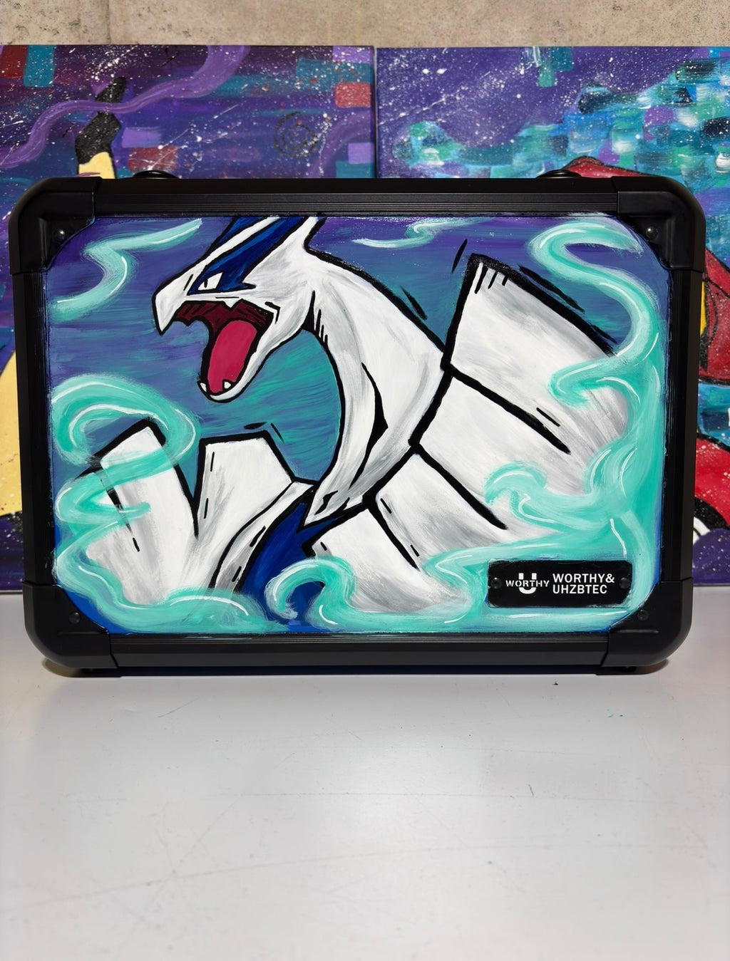 Front view of custom hand-painted Lugia 3-row slab case — white Lugia with teal psychic energy swirls on deep blue background, freehand acrylic artwork by 5/14 Apparel