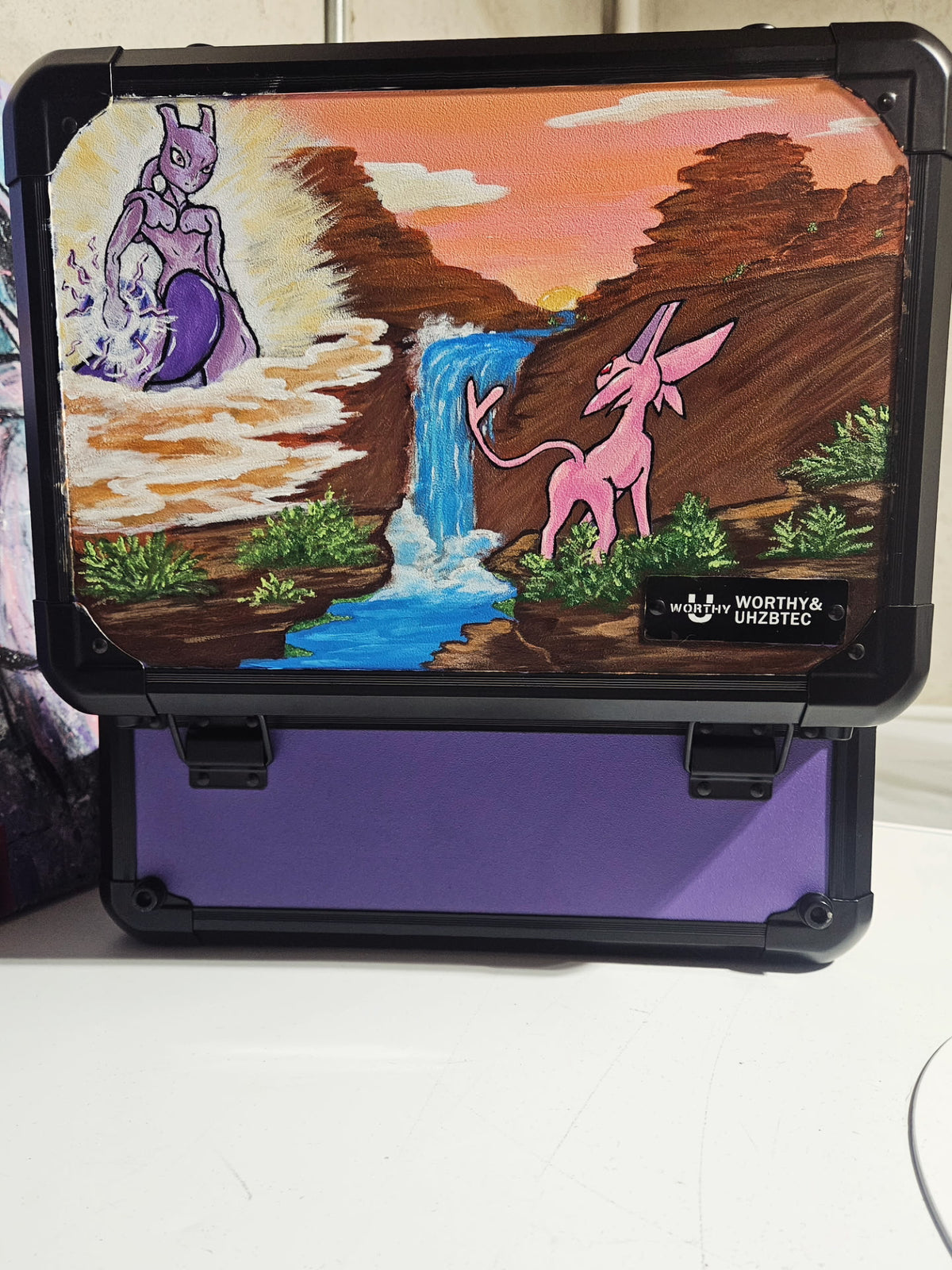 5/14 Apparel custom hand-painted Mewtwo and Espeon slab case — Mewtwo in psychic energy above clouds and Espeon beside canyon waterfall at golden hour sunset, one-of-one acrylic art on Worthy and UHZBTEC slab case