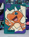 Front view of custom hand-painted Mega Dragonite VaultX binder — orange Dragonite bursting through geometric shards on teal and purple background, freehand acrylic artwork by 5/14 Apparel